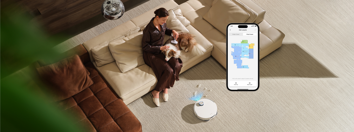 Woman with dog on a rug, X60 Ultra Complete cleaning nearby, app showing carpet zones