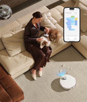Woman with dog on a rug, X60 Ultra Complete cleaning nearby, app showing carpet zones