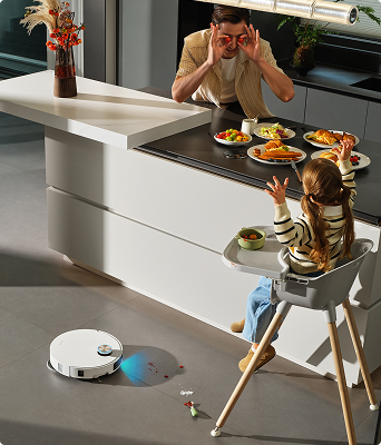 Father and daughter having breakfast while the X60 Ultra Complete cleans nearby